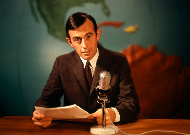 1960s Reporter Reading News Into Microphone With Global Map In Background